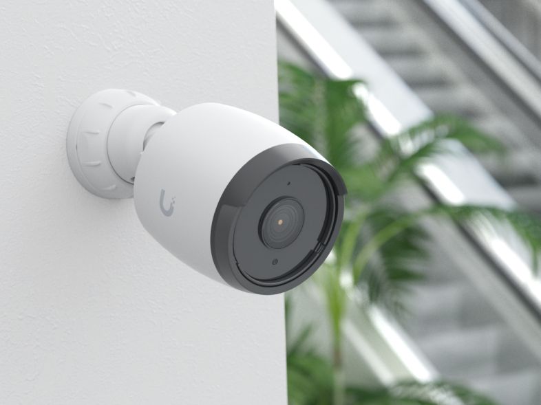 A white Ubiquiti UniFi Protect bullet camera mounted on a wall