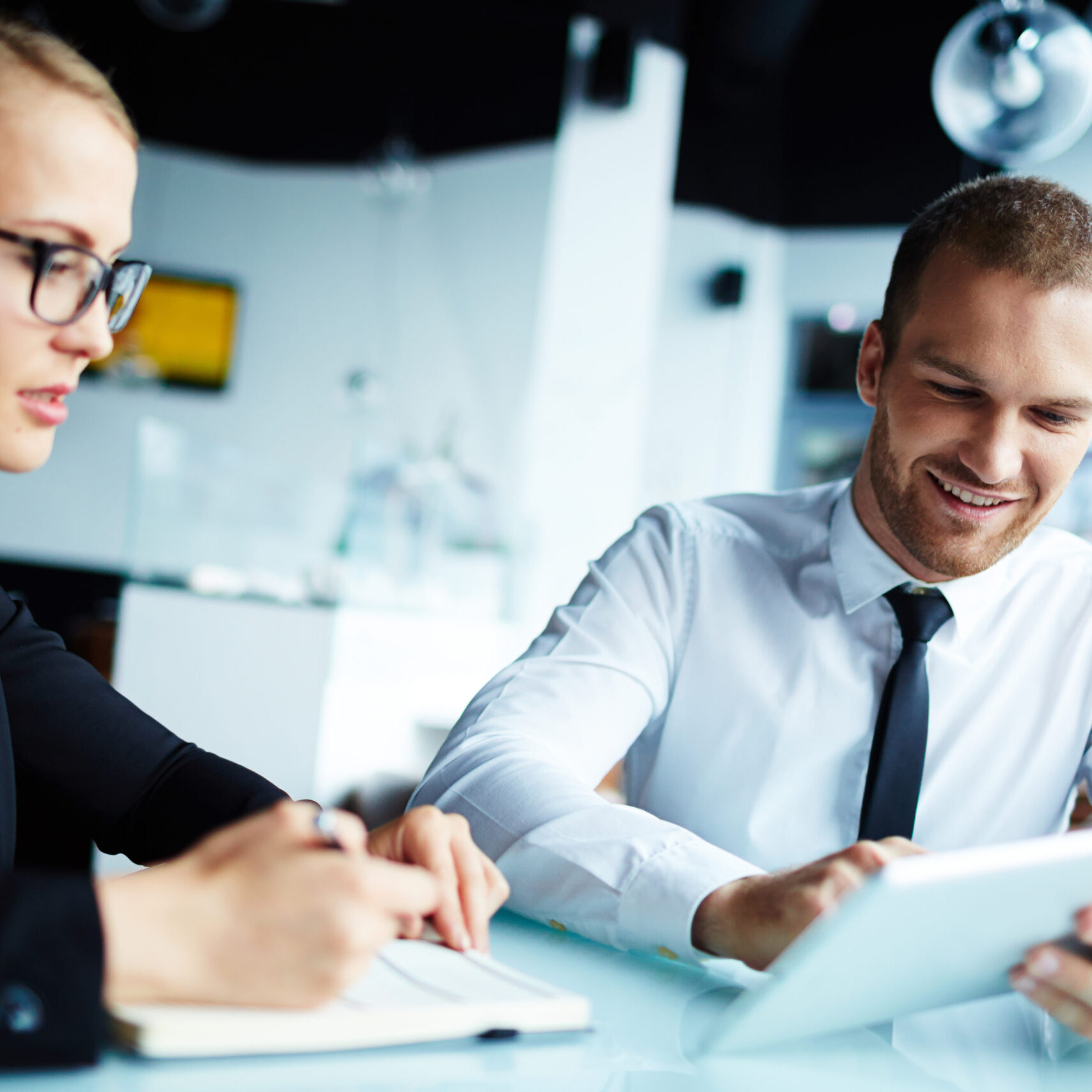 Businessman showing his colleague new data in touchpad